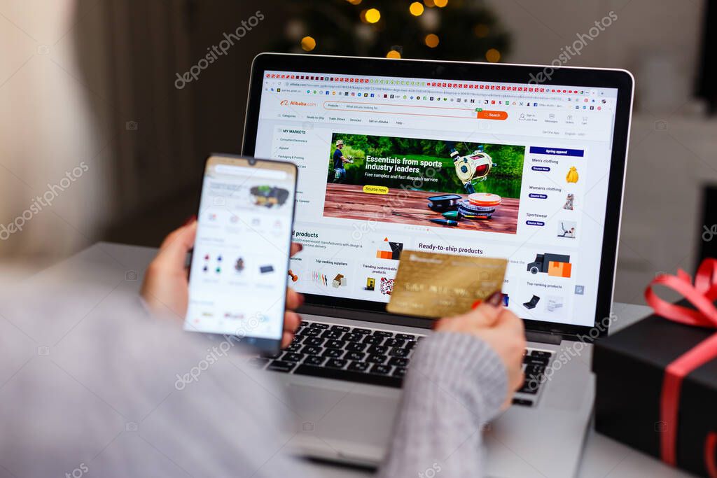 Kyiv, Ukraine - November 27, 2019: A cell phone, credit card, laptop on the table a with ali express apps on screen. Alibaba the the world biggest online commerce