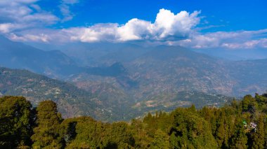 Dağların tepe manzarası ve bulutlu mavi gökyüzü sisli bir günde.