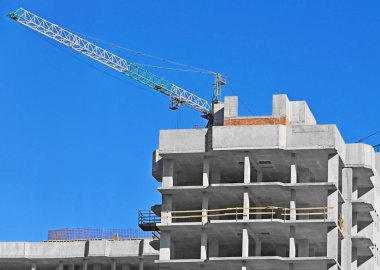 Mavi gökyüzüne karşı vinç ve inşaat yapmak