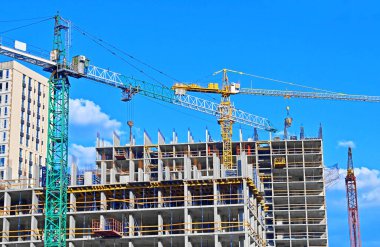 Vinçli ve gökyüzü olan çok aşamalı inşaat alanı