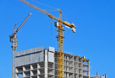 Mavi gökyüzüne karşı kule vinci ve inşaat