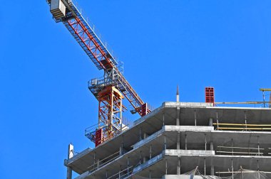 Vinçli ve mavi gökyüzü olan yüksek katlı bir inşaat alanı
