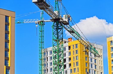 Vinçli ve mavi gökyüzü olan yüksek inşaat alanı