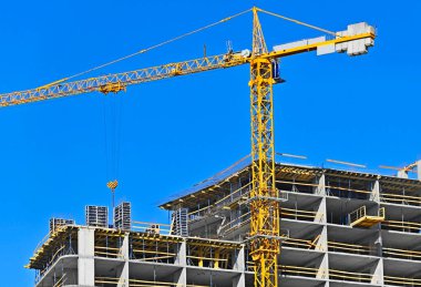 Mavi gökyüzüne karşı vinç ve inşaat yapmak