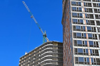 Vinçli ve gökyüzü olan çok aşamalı inşaat alanı