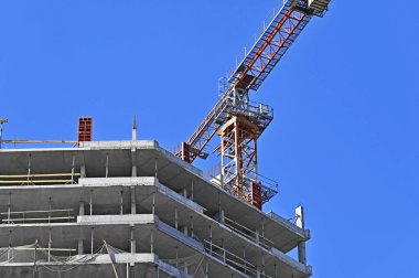 Vinçli ve mavi gökyüzü olan yüksek inşaat alanı