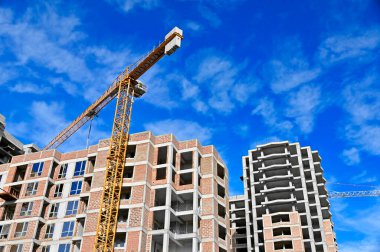 Mavi gökyüzüne karşı vinç ve inşaat yapmak