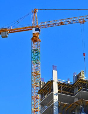 Mavi gökyüzüne karşı kule vinci ve inşaat