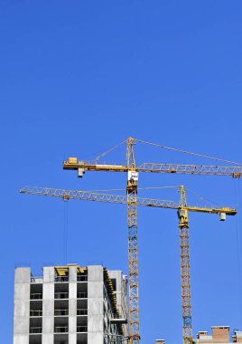 Mavi gökyüzüne karşı kule vinci ve inşaat