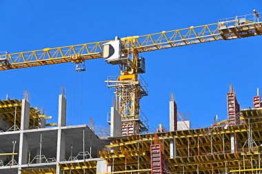 Mavi gökyüzüne karşı vinç ve inşaat yapmak