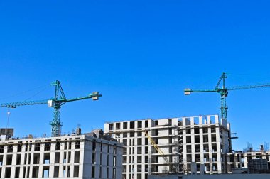Mavi gökyüzüne karşı vinç ve inşaat yapmak