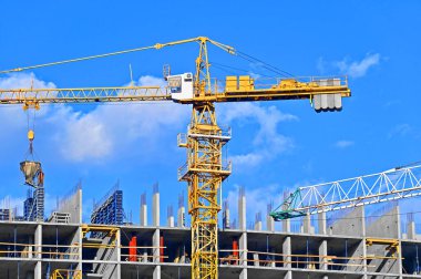 Mavi gökyüzüne karşı vinç ve inşaat yapmak