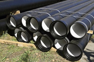 İnşaat alanına istiflenmiş güçlendirilmiş beton kanalizasyon boruları.