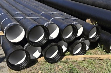 İnşaat alanına istiflenmiş güçlendirilmiş beton kanalizasyon boruları.