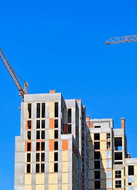 Mavi gökyüzüne karşı vinç ve inşaat alanı