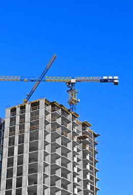 Mavi gökyüzüne karşı vinç ve inşaat alanı