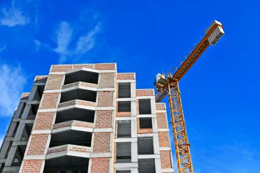 Mavi gökyüzüne karşı vinç ve inşaat yapmak