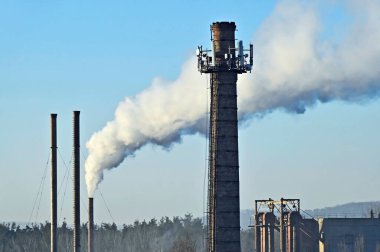 Sanayi bölgesinde dumanı olan eski fabrika bacası.