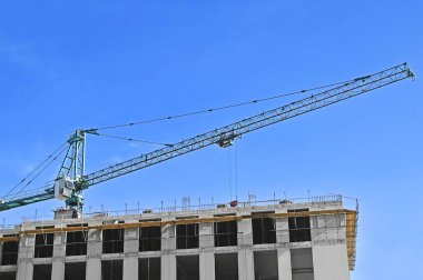 Mavi gökyüzüne karşı kule vinci ve inşaat