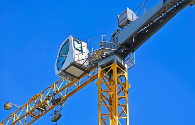 Mavi gökyüzüne karşı yüksek inşaat kulesi vinci