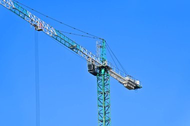 Mavi gökyüzüne karşı yüksek inşaat kulesi vinci