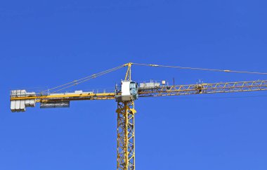 Mavi gökyüzüne karşı yüksek inşaat kulesi vinci