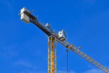 Mavi gökyüzüne karşı yüksek inşaat kulesi vinci