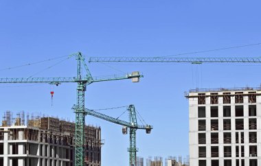 Vinçli ve mavi gökyüzü olan yüksek inşaat alanı