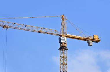 Mavi gökyüzüne karşı yüksek inşaat kulesi vinci