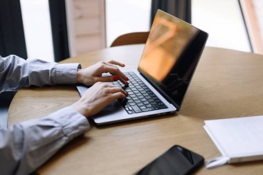 Evde ya da modern ofiste dizüstü bilgisayarda yazan bir kadın. Serbest çalışma ya da öğrenim ortamı.