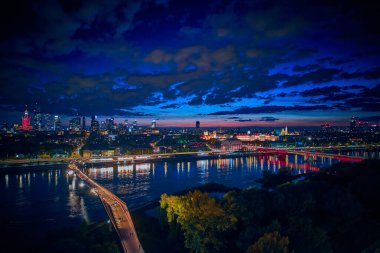 Vistula, Varşova, Polonya ve AB 'yi birbirine bağlayan yeni yaya ve bisiklet köprüsüne güzel panoramik hava aracı gece batımı görüntüsü.