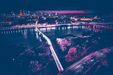 Vistula, Varşova, Polonya ve AB 'yi birbirine bağlayan yeni yaya ve bisiklet köprüsüne güzel panoramik hava aracı gece batımı görüntüsü.
