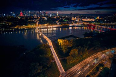 Vistula, Varşova, Polonya ve AB 'yi birbirine bağlayan yeni yaya ve bisiklet köprüsüne güzel panoramik hava aracı gece batımı görüntüsü.