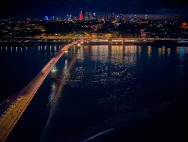 Vistula, Varşova, Polonya ve AB 'yi birbirine bağlayan yeni yaya ve bisiklet köprüsüne güzel panoramik hava aracı gece batımı görüntüsü.