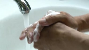 El yıkama, anti bakteriyel sabun, ovma, köpürtme ve temizleme beyaz lavabo altında akan musluk suyu altında yakın görünüm.