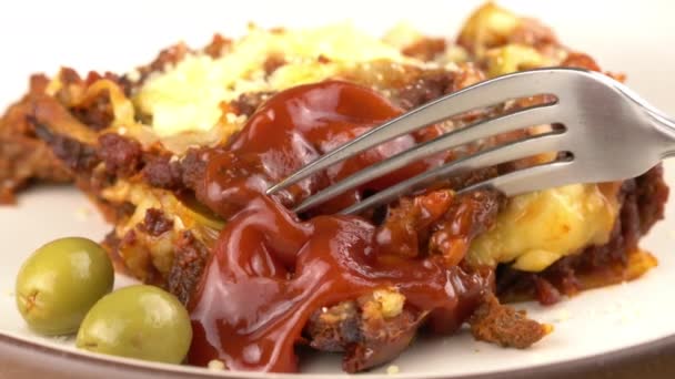 用金属叉子咬一口意大利自制的食物 意大利面 用番茄酱和橄榄倒入褐色陶瓷盘 — 图库视频影像