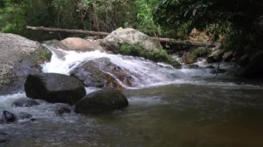 Natural mountain stream water hits and flowing over big rocks at Chae Son Waterfalls in Chae Son National Park of Thailand.