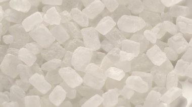 Top view pile of organic crystaline sugar rotated on the floor. Refined crystaline cane sugar as a background.
