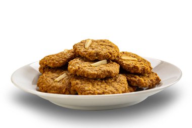 Beyaz arka planda izole edilmiş beyaz seramik tabakta ev yapımı lezzetli hindistan cevizi kurabiyeleri yığını.