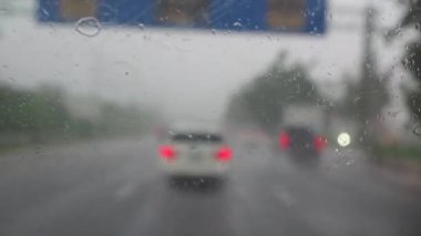 Şiddetli yağmur mevsiminde karayolunda trafik vardı. Şiddetli yağmurda çalışan arabanın ön camından bak. Silecek ön camı temizliyor..