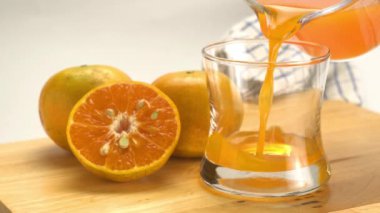Taze portakal suyunu olgun portakal meyveleriyle şeffaf bardağa dökerek..