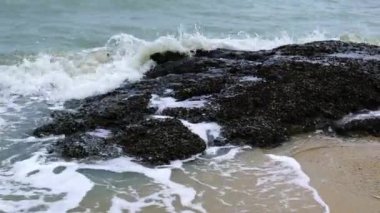 Dalgalar Pattaya şehrindeki büyük kayaların üzerine çarpıyor. Pattaya şehri Tayland 'ın en ünlü tatil beldelerinden biridir..