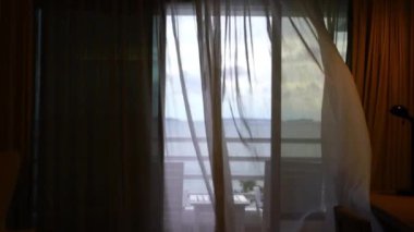 Pattaya otel odasının açık cam kapısından esen deniz esintisi ince perdeyi sallıyor..