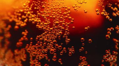 Buzlu kola bardağındaki hava kabarcıklarının yakın görüntüsü döndürüldü. Kola su ve buzdan oluşan hava kabarcıkları olan şeffaf camların dönüşü.