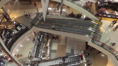 Modern alışveriş merkezinin yürüyen merdiven kullanıcısı. Gezginler ve ziyaretçiler büyük bir alışveriş merkezinde yürüyor ve alışveriş yapıyorlar..