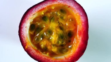 Beyaz arka planda yarı tutkulu meyvelerin üst görünümü, hamuru ve tohumları gösterir.