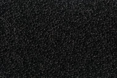 Siyah mutfak süngerinin soyut arkaplanı. Siyah mutfak temizleme süngerinin doku yüzeyinin görünümü, arka plan.