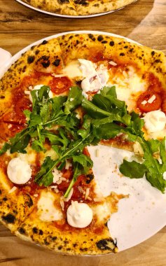 Klasik İtalyan pizzası, stracciatella ve roka. Masanın üstünden manzaralı..