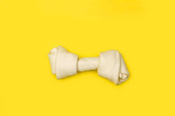 Kość Rawhide Żółtym Tle Przestrzenią Kopiowania — Zdjęcie stockowe