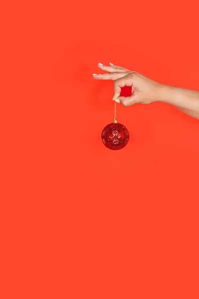 Жінка Рука Тримає Червоний Різдвяний Кульковий Орнамент Червоному Тлі Пробілом — стокове фото